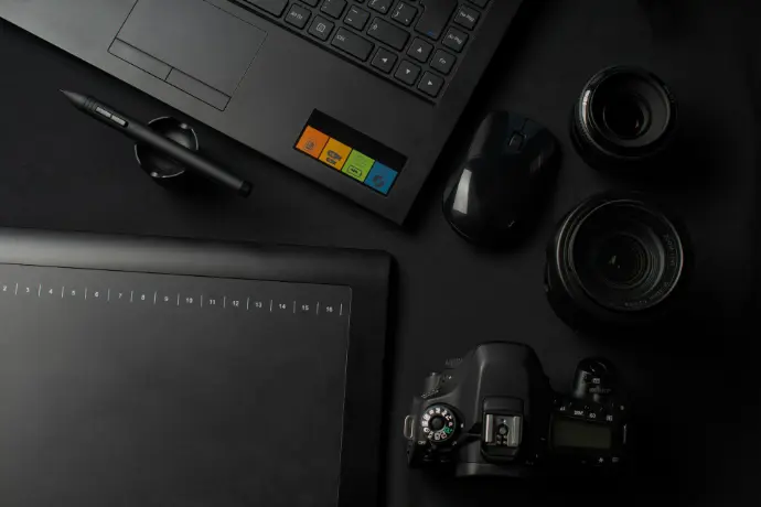 black DSLR camera besides computer mouse